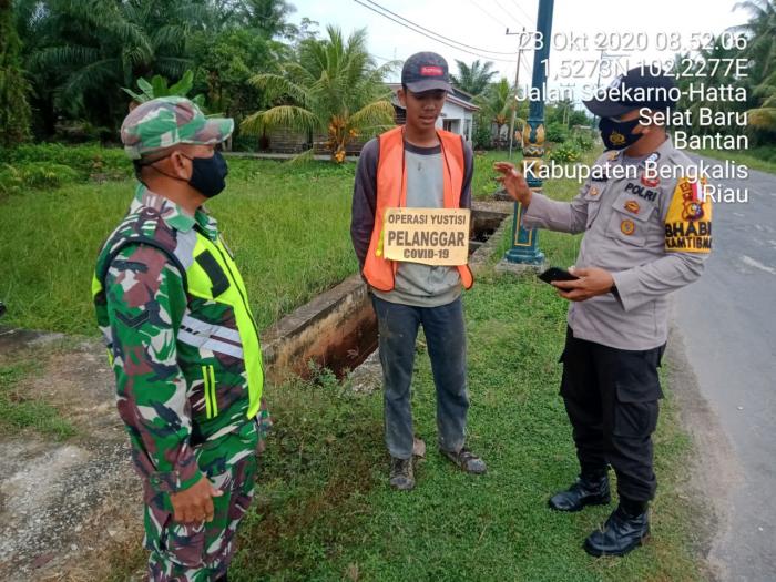 Serda Armansyah dan Serda A. Zamzuri Ingatkan Masyarakat Menggunakan Masker
