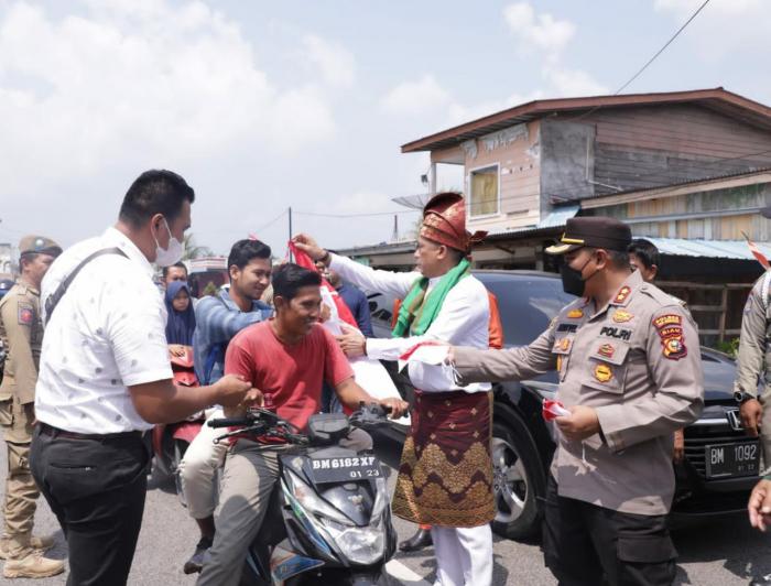 Dampingi Bupati Adil, Kapolres Meranti Ikut Bagikan Ratusan Bendera Merah Putih kepada Masyarakat