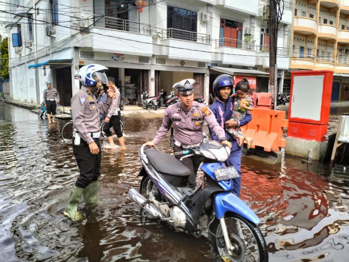 Wujud Polisi Peduli Keselamatan, Personel Satlantas Bantu Warga Lewati Jalan Terendam Banjir