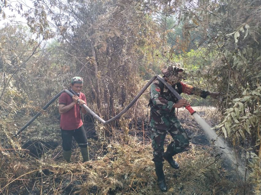 Anggota Koramil 02/Tebing Tinggi Bersama Tim Lakukan Pendinginan Karhutla di Desa Sungai Gayung Kiri